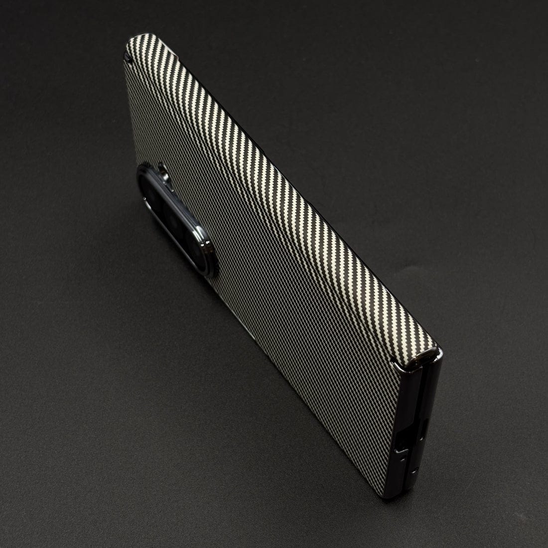 Carbon fiber phone case on a dark background