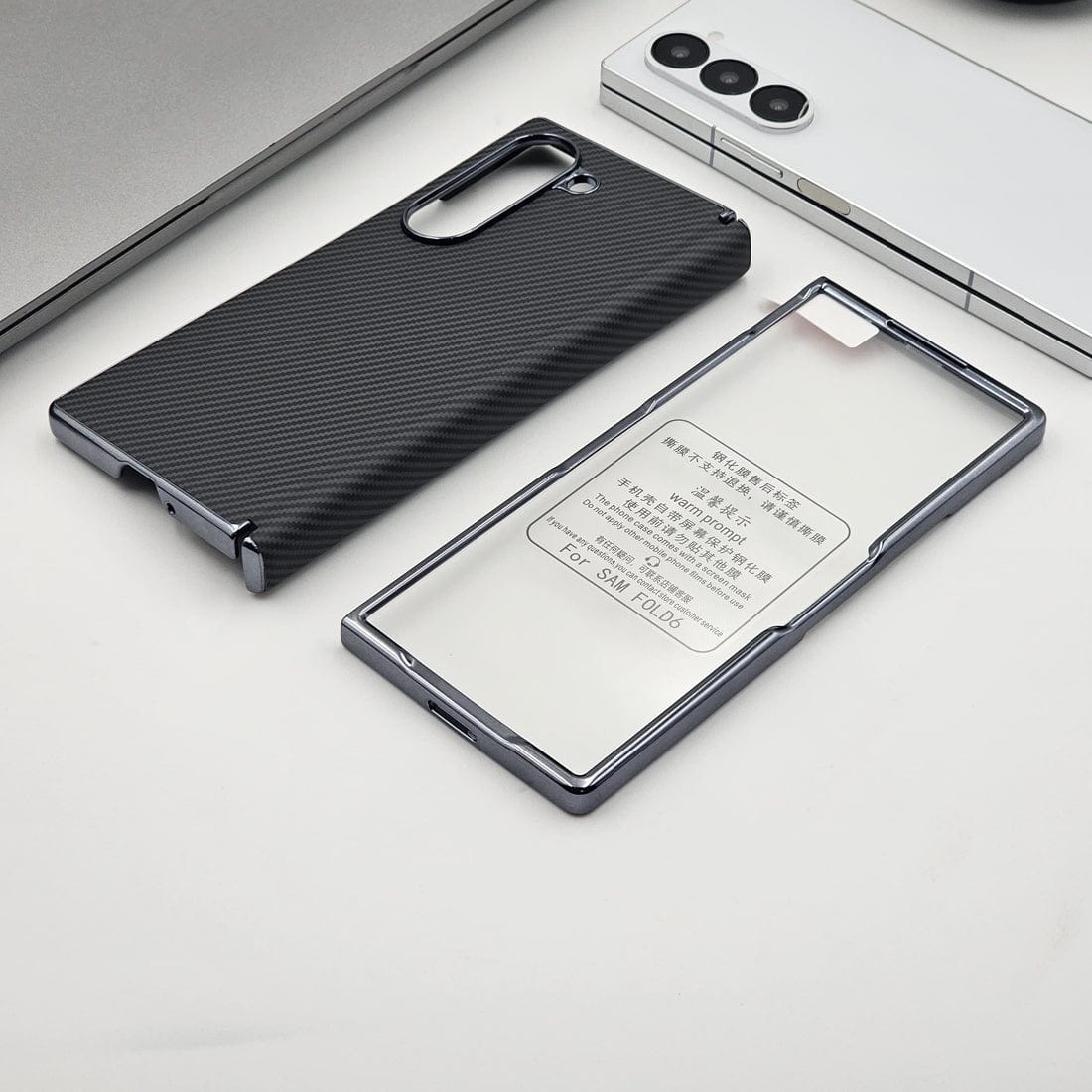 Two phone cases, one black and one transparent with text, on a light gray surface.